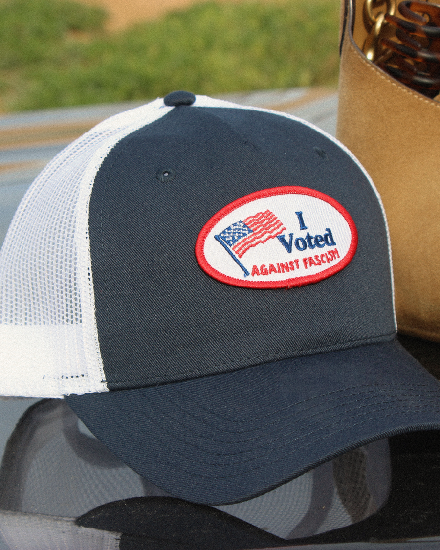 404 Collective Civic Duty Trucker hat lifestyle shot — activist streetwear